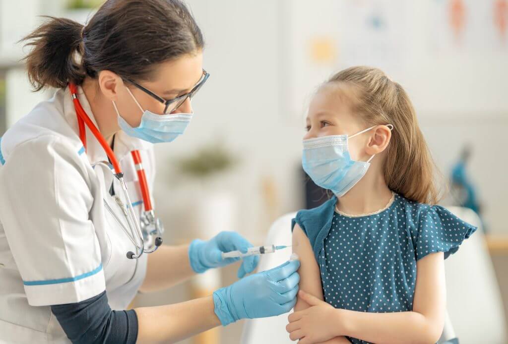 Doctora vacunando a una niña pequeña