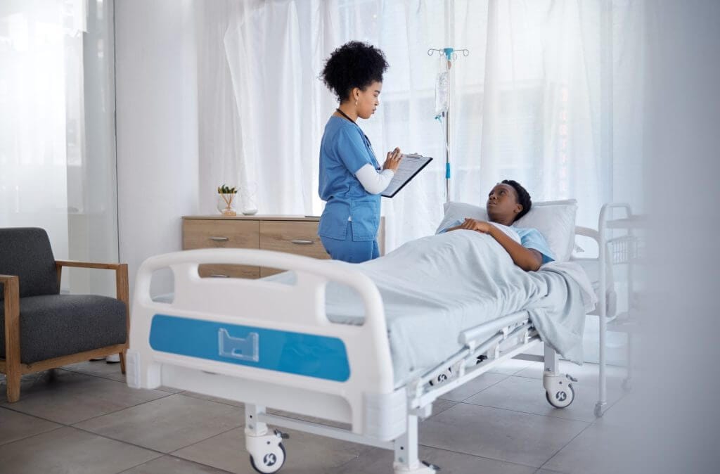 Paciente siendo atendido en una cama de hospital por la enfermera