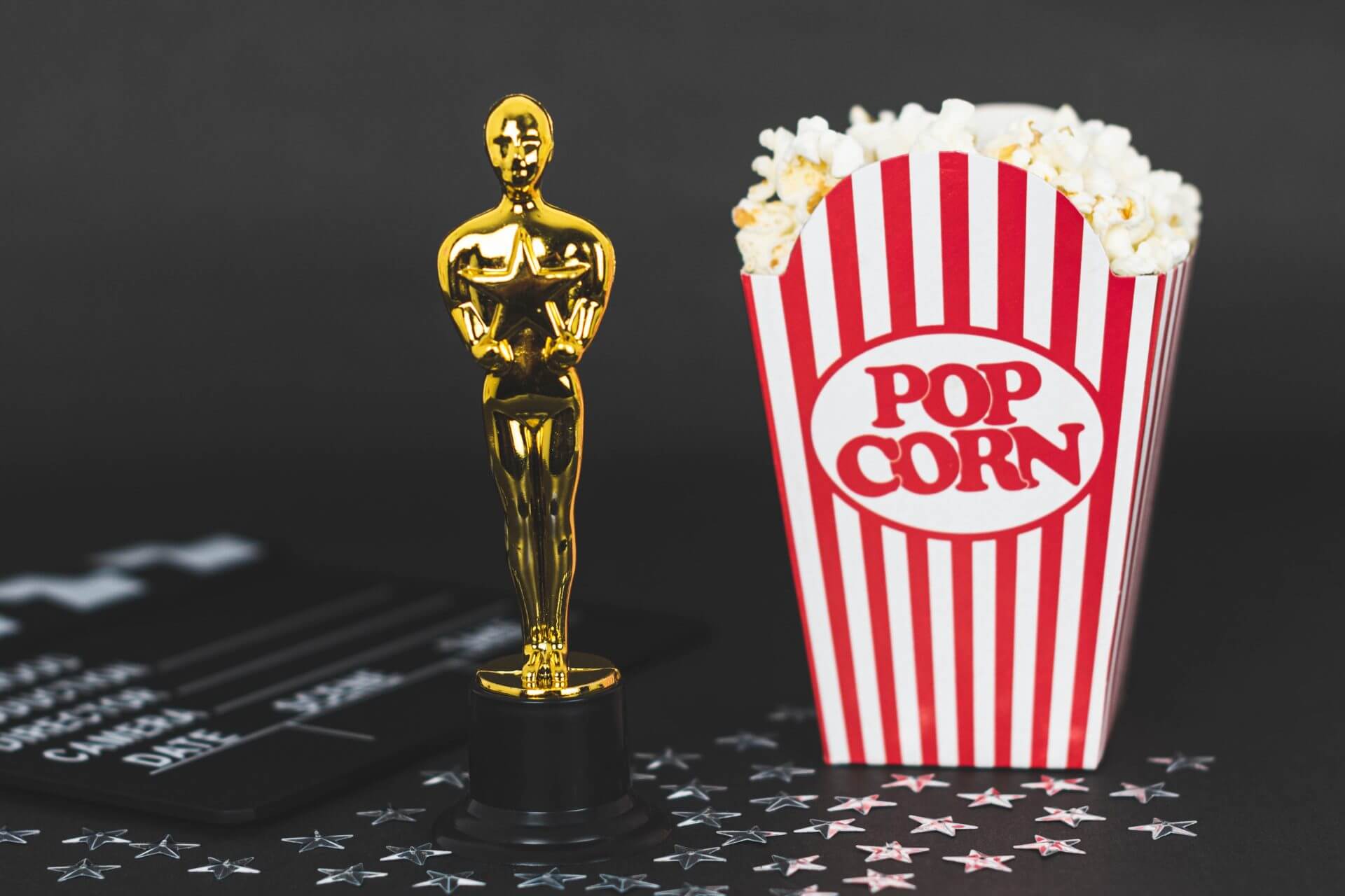 Premio Oscar junto a popcorn celebrando los latinos nominados al Oscar