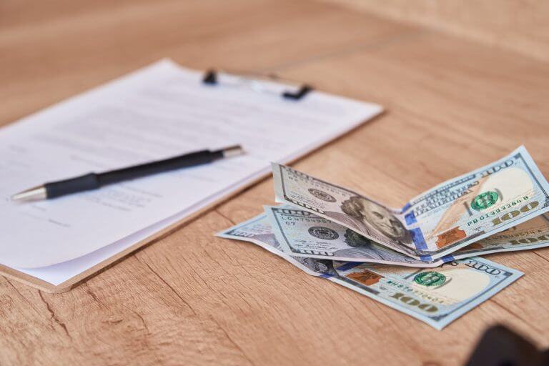 Dinero y documentos sobre una mesa para realizar el pago de tarifas de inmigración