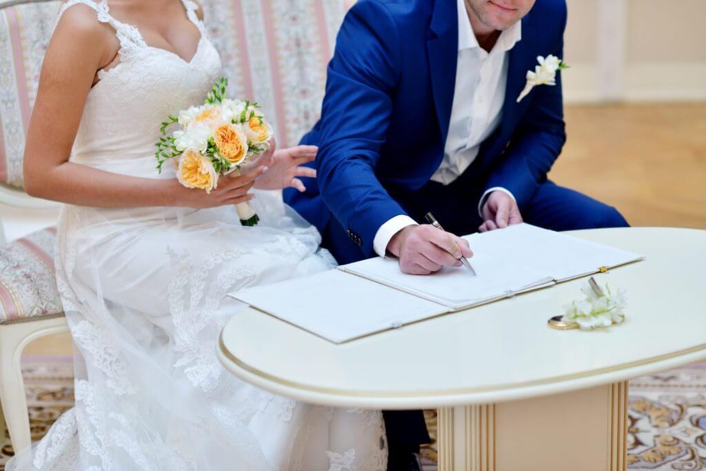 Novio y novia en su boda firmando los documentos de matrimonio