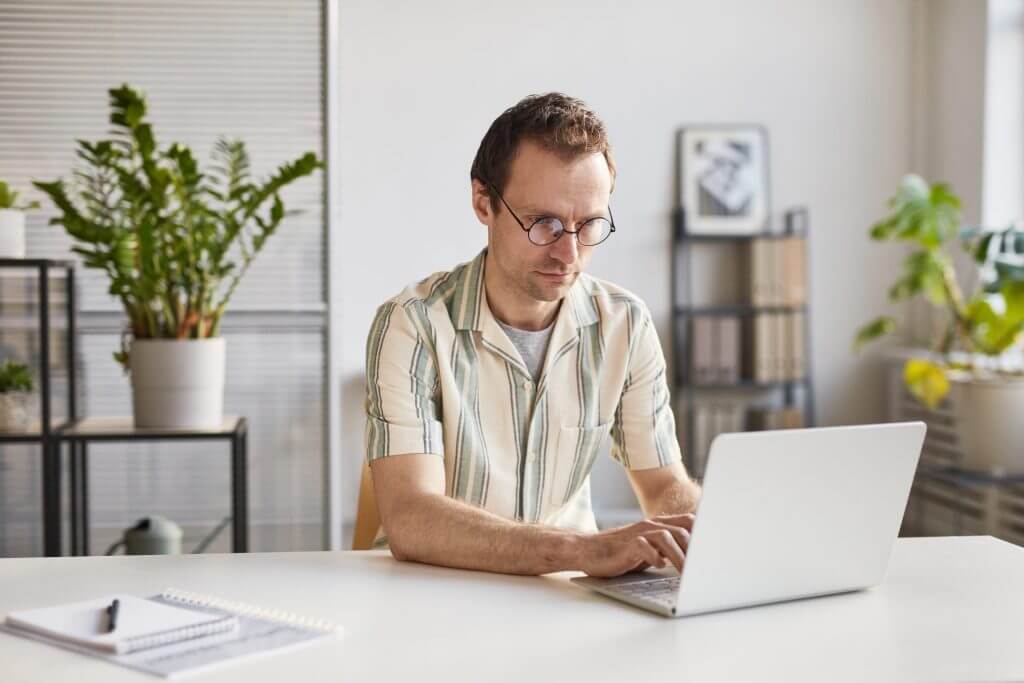 Hombre revisando su estatus migratorio en su laptop