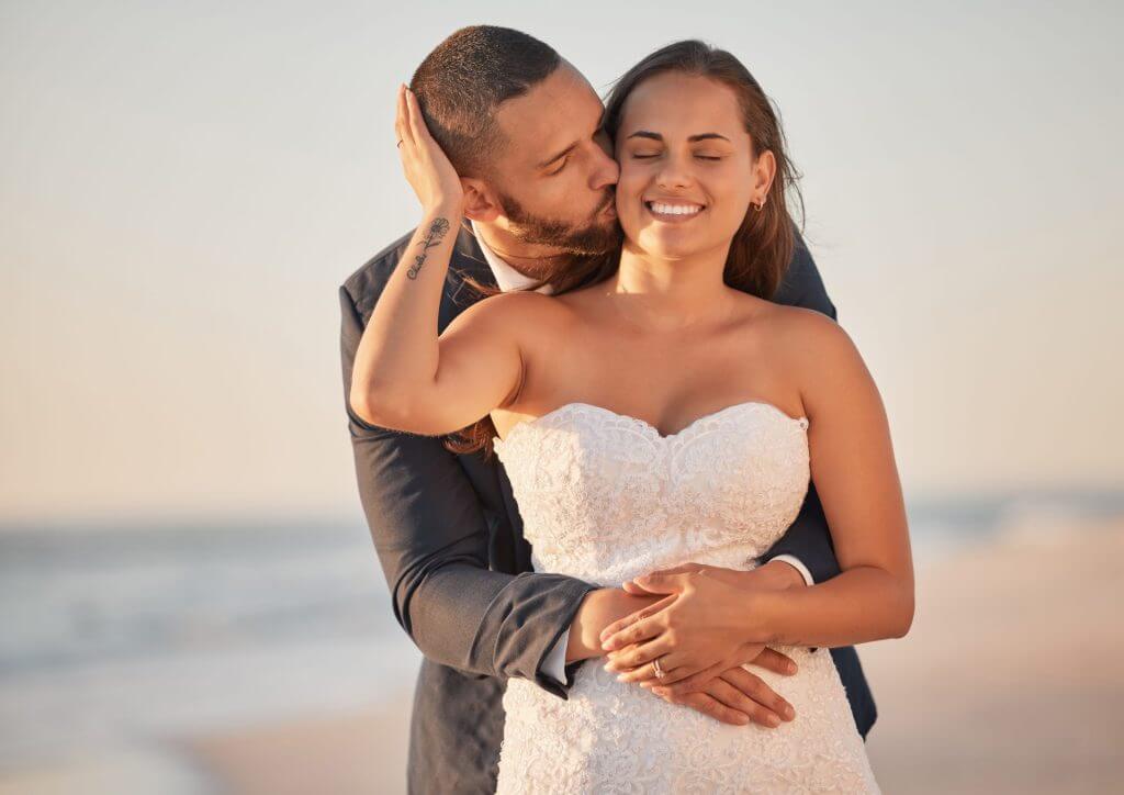 Pareja recién casada feliz en la playa de USA