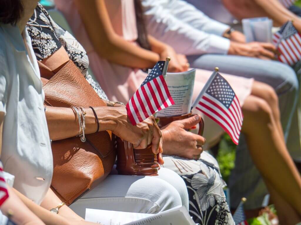 Grupo de futuros ciudadanos americanos con la bandera de USA en la mano