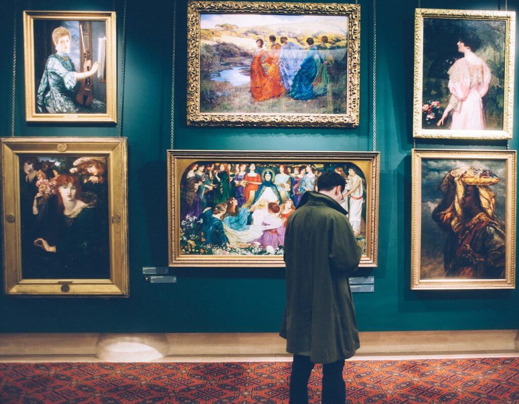 Visitante mirando obras de arte en un museo