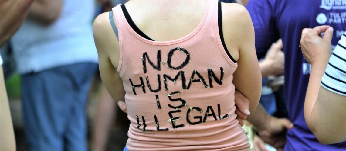 Joven con remera No Human is Illegal. Nota sobre tps extension 2022