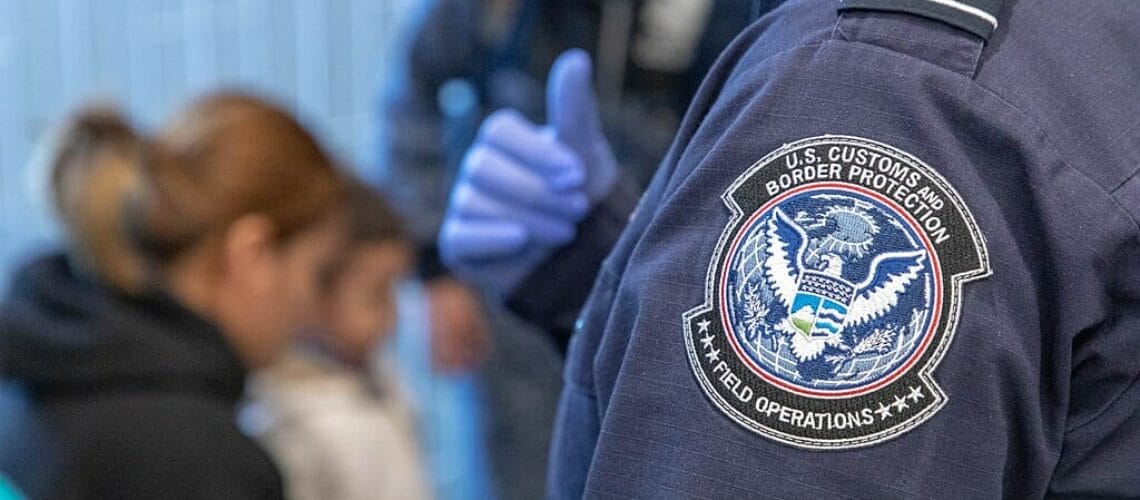 Oficial fronterizo procesa a inmigrantes solicitando asilo.