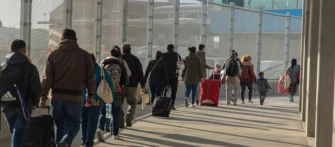 Este artículo habla sobre la nueva política de asilo en la frontera. La imagen muestra a un grupo de solicitantes haciendo fila para ser procesados en un punto de ingreso.