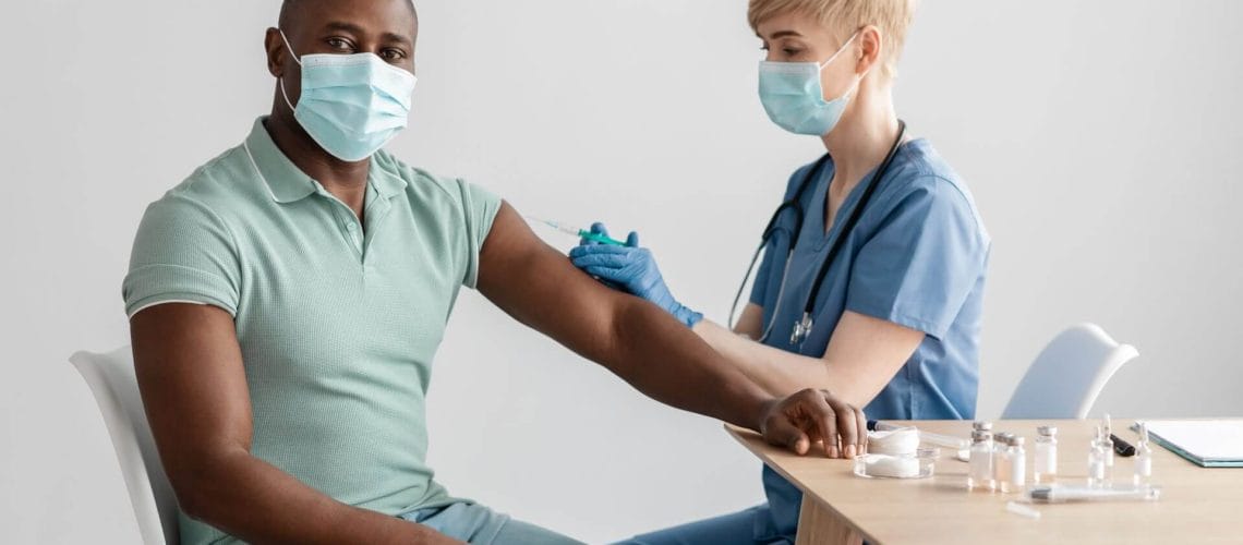 Hombre recibiendo vacunas gracias al seguro medico en estados unidos para inmigrantes