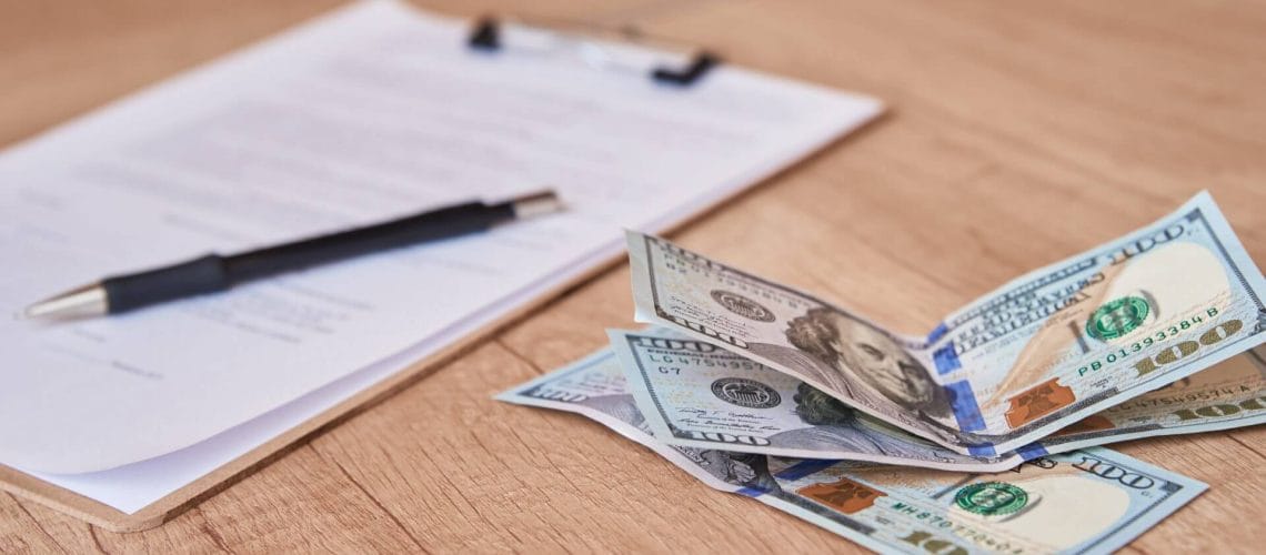Dinero y documentos sobre una mesa para realizar el pago de tarifas de inmigración