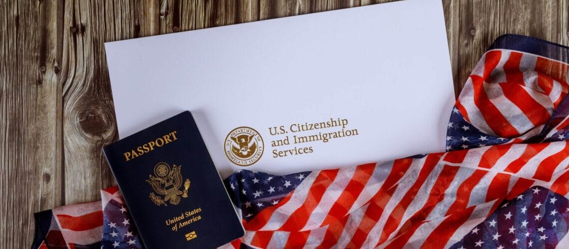 Pasaporte de USA junto a la bandera y un documento de ciudadanía representando la ayuda para aplicar para la ciudadania